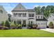Charming two-story white home featuring a welcoming front porch and well-manicured lawn at 2993 Club Dr, Raleigh, NC 27613