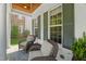 Inviting front porch with stone floors, white columns, wood ceiling, and wicker furniture at 2993 Club Dr, Raleigh, NC 27613