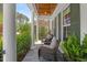 Charming front porch with stone floors, white columns, wood ceiling, and wicker furniture at 2993 Club Dr, Raleigh, NC 27613