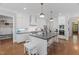 Bright, open kitchen with an island, pendant lighting, stainless appliances, and white cabinetry at 2993 Club Dr, Raleigh, NC 27613