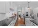 Bright kitchen with stainless steel appliances, white cabinetry, black countertops, and hardwood floors at 2993 Club Dr, Raleigh, NC 27613