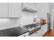Bright kitchen with stainless steel appliances, white cabinetry, black counters and subway tile backsplash at 2993 Club Dr, Raleigh, NC 27613