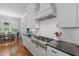 Bright kitchen with stainless steel appliances, white cabinetry, black counters and a view to the eating nook at 2993 Club Dr, Raleigh, NC 27613