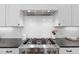 Bright kitchen featuring stainless steel stove and hood, subway tile backsplash, and black countertops at 2993 Club Dr, Raleigh, NC 27613