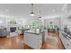 Open concept kitchen and living room with stainless steel appliances, island seating and hardwood floors at 2993 Club Dr, Raleigh, NC 27613