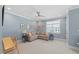 Living room with soft blue walls, light carpet, ceiling fan, and multiple picture frames at 2993 Club Dr, Raleigh, NC 27613