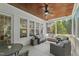 Inviting screened porch featuring comfortable seating, a ceiling fan, a wood ceiling and views of the surrounding landscape at 2993 Club Dr, Raleigh, NC 27613
