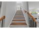 Elegant staircase with wooden treads and handrails, contrasted by white risers and walls, leads to upper level at 2993 Club Dr, Raleigh, NC 27613