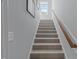 Carpeted staircase with white walls, wood railing and natural light streaming through the window at 2993 Club Dr, Raleigh, NC 27613