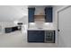 Elegant wet bar with navy blue cabinetry, quartz counters, backsplash, wine fridge, and open shelving at 2993 Club Dr, Raleigh, NC 27613
