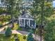 Aerial view of landscaped property with circular driveway and classic home design at 300 S Pine St, Benson, NC 27504