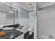Modern bathroom featuring sleek fixtures, a dark countertop, a shower, and a commode at 300 S Pine St, Benson, NC 27504