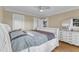 A bright bedroom with white furniture, neutral walls, and a view of the yard through the windows at 300 S Pine St, Benson, NC 27504