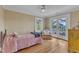 Bright bedroom with hardwood floors, ceiling fan, and doors to the outside at 300 S Pine St, Benson, NC 27504