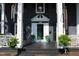 Inviting front porch with decoratively painted entry door and manicured landscaping at 300 S Pine St, Benson, NC 27504