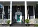 Inviting front porch with white columns and a vibrant turquoise front door at 300 S Pine St, Benson, NC 27504