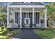 Inviting covered front porch with decorative columns, seating area, and manicured landscaping at 300 S Pine St, Benson, NC 27504