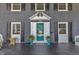 Front porch featuring a quaint door and sidelights, adorned with potted plants at 300 S Pine St, Benson, NC 27504