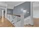 Hallway featuring white trim, wood flooring, decorative railing and a neutral-colored accent wall at 300 S Pine St, Benson, NC 27504