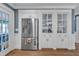 Modern kitchen with stainless steel refrigerator, glass cabinets, and hardwood floors at 300 S Pine St, Benson, NC 27504