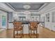 Beautiful kitchen with a large island, barstool seating, modern lighting, white cabinets and hardwood floors at 300 S Pine St, Benson, NC 27504
