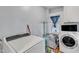 Neat laundry room featuring a washing machine, dryer, window and storage at 300 S Pine St, Benson, NC 27504