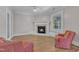 An open living room features chairs, a fireplace, and hardwood floors, with a door to the outside at 300 S Pine St, Benson, NC 27504