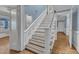 View of staircase featuring hardwood steps and flooring with decorative white risers and trim at 300 S Pine St, Benson, NC 27504