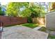 Landscaped backyard featuring a privacy fence, small storage shed, and a brick wall at 3029 Wycliff Rd, Raleigh, NC 27607