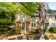 Charming brick and siding townhouse with a vibrant green door and lush landscaping at 3029 Wycliff Rd, Raleigh, NC 27607