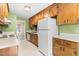 Practical kitchen featuring wood cabinets, white appliances, and ample counter space at 3029 Wycliff Rd, Raleigh, NC 27607