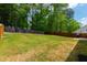 Spacious backyard with a wooden fence, lush green grass, and mature trees for privacy and shade at 303 Forestview Crest Way, Fuquay Varina, NC 27526