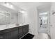 Bathroom featuring double sinks, dark vanity, and a doorway to the walk-in closet at 303 Forestview Crest Way, Fuquay Varina, NC 27526
