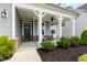 Inviting covered front porch featuring neutral chairs and well-maintained landscaping at 303 Forestview Crest Way, Fuquay Varina, NC 27526