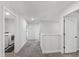 Upstairs hallway with carpeted floors leading to the laundry room with washer and dryer at 303 Forestview Crest Way, Fuquay Varina, NC 27526