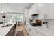 Bright kitchen featuring white cabinets, quartz countertops, and stainless steel appliances at 303 Forestview Crest Way, Fuquay Varina, NC 27526