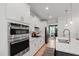 Bright, modern kitchen with stainless steel appliances, white cabinets, and quartz countertops at 303 Forestview Crest Way, Fuquay Varina, NC 27526