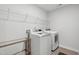 Modern laundry room features a washer, dryer, shelving, and a glass side table for convenience at 303 Forestview Crest Way, Fuquay Varina, NC 27526