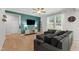 Cozy living room with a large sectional sofa, ceiling fan, and a view of the backyard at 303 Forestview Crest Way, Fuquay Varina, NC 27526