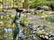 Beautiful backyard featuring mature landscaping, a pond, a waterfall, and lawn furniture at 307 Clayton Rd, Chapel Hill, NC 27514