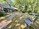 Relaxing backyard with mature trees, stone walkway, and comfortable rocking chairs at 307 Clayton Rd, Chapel Hill, NC 27514