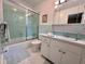 Bright bathroom featuring a shower over bath with glass screen, white tile, and vanity at 307 Clayton Rd, Chapel Hill, NC 27514