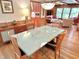 Open dining area with a modern glass table and wood chairs, seamlessly flowing into the living space at 307 Clayton Rd, Chapel Hill, NC 27514