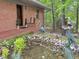 Charming brick home with mature landscaping, a small fish pond, and decorative statues at 307 Clayton Rd, Chapel Hill, NC 27514