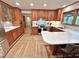 Spacious kitchen with stainless appliances, wood cabinets, large island and herringbone-patterned wood flooring at 307 Clayton Rd, Chapel Hill, NC 27514