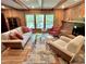 Inviting living room featuring a brick fireplace, exposed beams, and large windows at 307 Clayton Rd, Chapel Hill, NC 27514