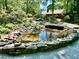 Landscaped pond with natural rock border and clear water, surrounded by lush greenery at 307 Clayton Rd, Chapel Hill, NC 27514