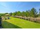 Spacious backyard featuring lush green grass and a patio area with an umbrella and seating at 324 Prides Xing, Rolesville, NC 27571