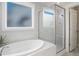 Spa-like bathroom showcasing a soaking tub, glass-enclosed shower, and elegant finishes at 324 Prides Xing, Rolesville, NC 27571
