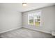 A cozy bedroom features neutral carpet and paint and a window at 324 Prides Xing, Rolesville, NC 27571